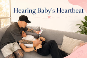 Dad leaning close to pregnant belly, mom's hand on his shoulder — sharing baby's heartbeat moment