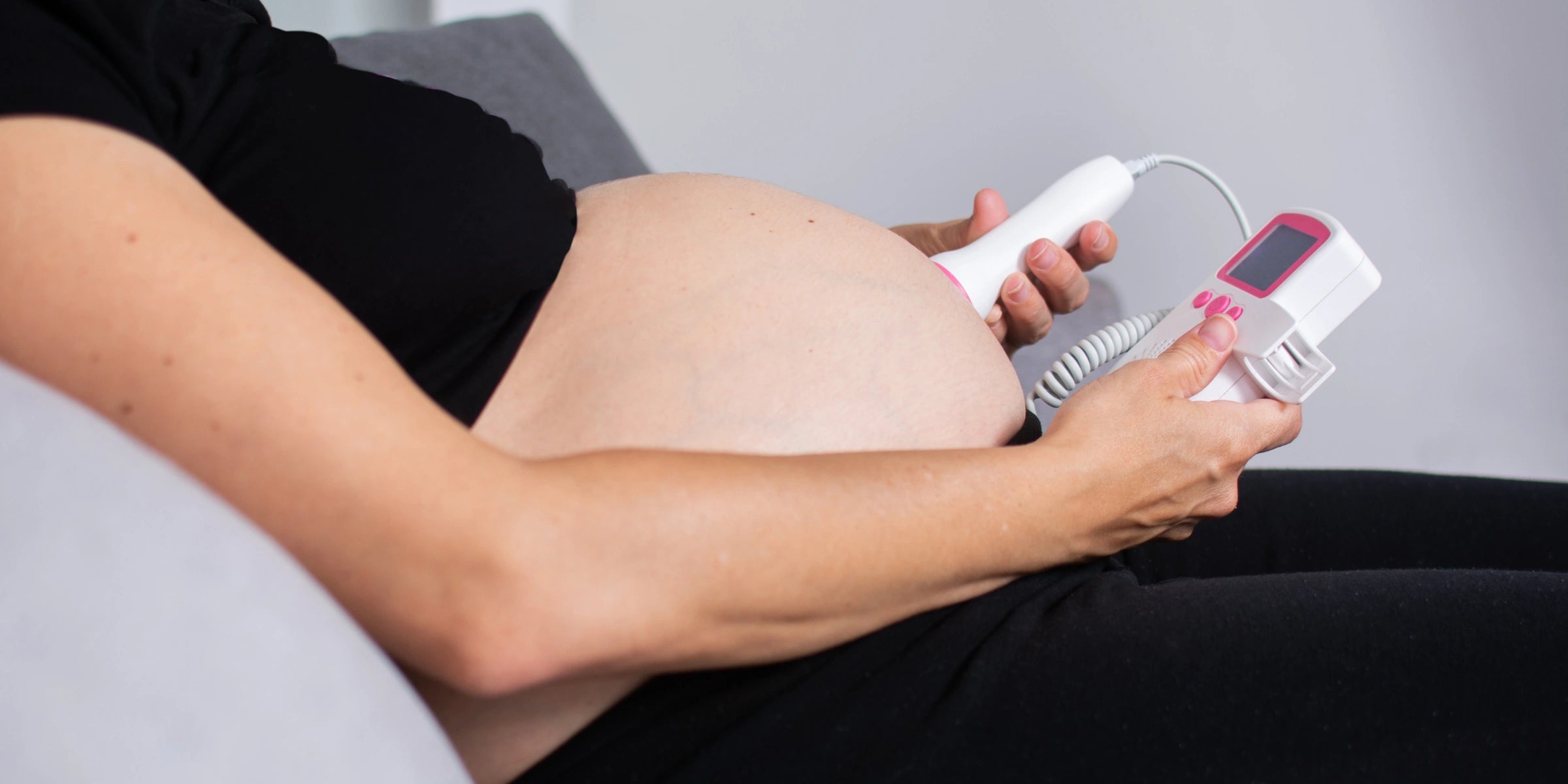 Pregnant woman using BabyEcho fetal doppler at home